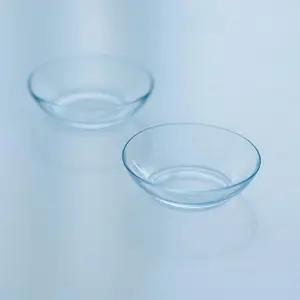 Two empty clear glass bowls on a blue surface.
