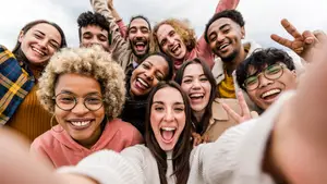 A group of young people with glasses are posing for a photo and smiling while standing next to each other. 