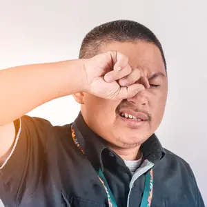 Man covering his nose with his hand, likely due to an unpleasant smell or irritation.