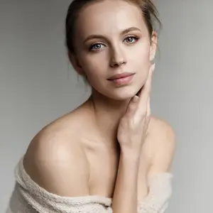 Woman posing for a portrait with a light background and a knitted shawl around her shoulders