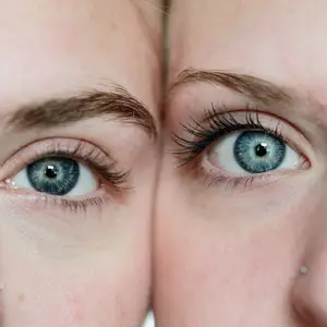 Close-up view of two women's eyes with blue eyes and brown eyebrows, one looking directly at the camera and the other looking to the left