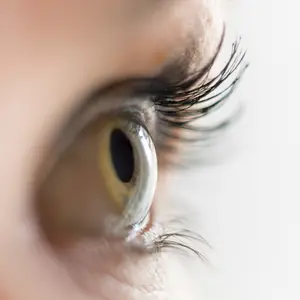 Close-up of a person's eye with brown iris and eyelashes