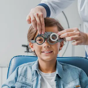A young boy wearing glasses and being examined by a doctor in a clinic.