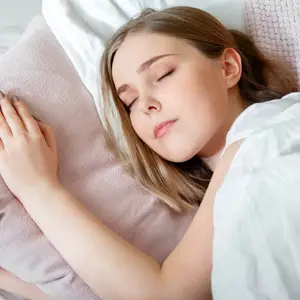 Woman sleeping peacefully with a pillow under her head and hand on her cheek