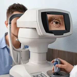 A man is getting an eye exam with a machine that shows a close-up image of his eye on a screen
