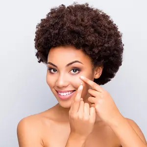 woman applying cream on her face with a smiling face