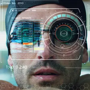 A man wearing glasses and a hat is shown with a futuristic-looking eye graphic overlay on his face, displaying various numbers and a video number at the top.