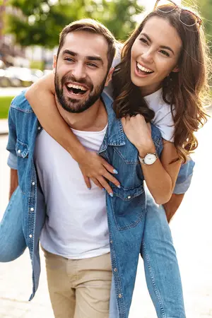 a couple in a park smiling at the camera