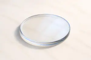 A clear plastic container with a silver rim is on a white marble surface.