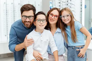 Four people in a family smiling and posing for a picture in a store