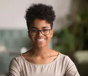Smiling woman wearing glasses, representing accepted vision insurance plans at Eye E Optical