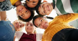 Group of smiling children forming a circle and posing for a photo