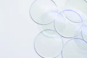 Transparent circular objects with blue lines possibly placed on a white surface