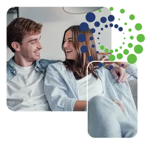 A man and woman smiling and laughing on a couch.