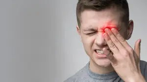 Man rubbing his eye with a red eye