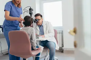 An optometrist performing a pediatric eye exam at Southampton Optiks in Southampton, NY