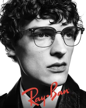 A man with glasses and a leather jacket with the word Ray-Ban on it