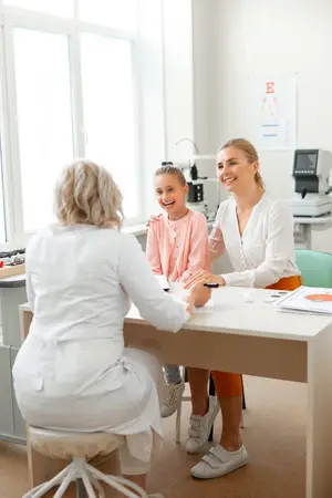 A girl smiles at the doctor during her eye exam