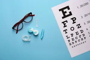 An eye chart, eyeglasses, contact lenses, and a contact lens case are on a blue background.