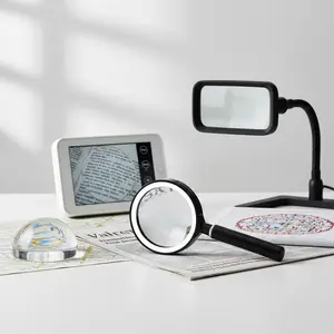 A table with a magnifying glass, a map, a tablet, and a reading lamp.