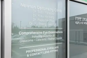 Newton Optometry Clinic signboard displaying comprehensive eye examinations, detection of diseases, and professional eyeglass and contact lens fitting services.