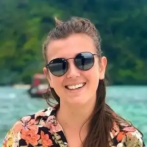A woman smiling and posing for a photo on the beach