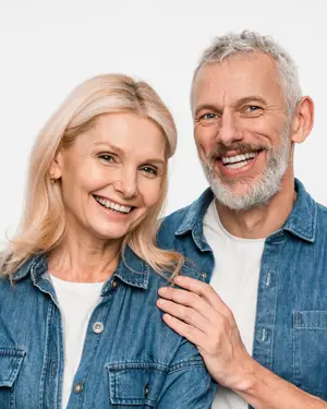 A couple smiling and posing for a photo with a white background