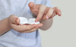 Close up of a child's hands holding a pair of contact lenses