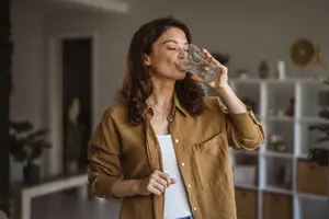 Woman drinking water in her room