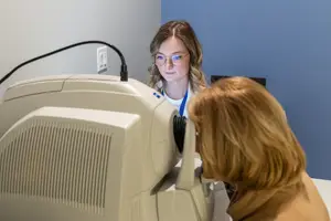 A woman is checking another woman's eyes with an eye-examination machine in an eye clinic.