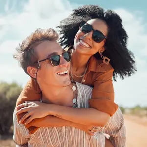 happy young couple outdoors wearing sunglasses