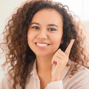 young woman holding contact lens on finger