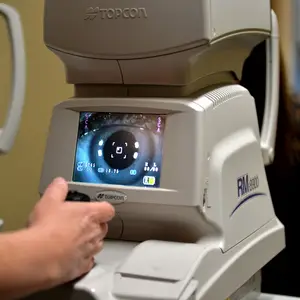 optometrist using topcon rm 8900 auto refractometer