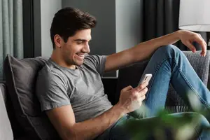 man sitting on sofa with smartphone