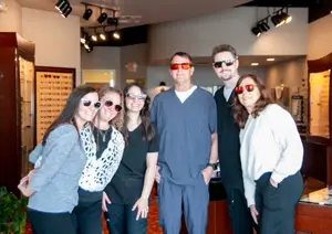 A group of people wearing sunglasses and standing in a room