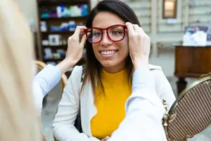 A woman is trying on a pair of glasses at Las Vegas Eye Exam in Las Vegas, NV.