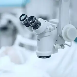 A close-up view of a microscope in a hospital room.