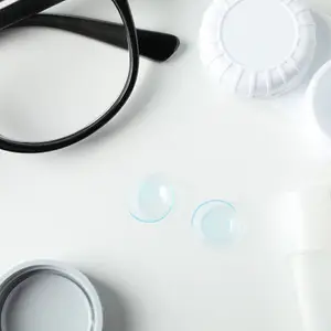 A pair of glasses with contact lenses on a white surface