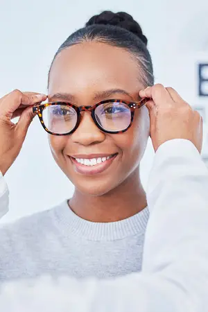 woman trying on glasses at optical shop