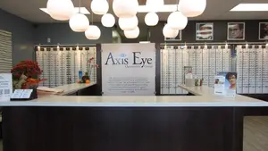 Axis Eye Optometric group reception desk with the sign Axis Eye Optometric Group and a large display of glasses.