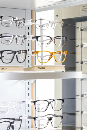 A display of Smith brand eyeglasses in a store with various frames and lenses on a shelf.