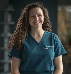 Dr. Sophia Carr in a teal medical scrub top with her hands on her hips