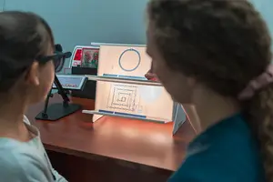 Two women using a microscope and a magnifying glass to look at an object on a stand