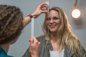 Woman smiling while having her eyes checked by a doctor