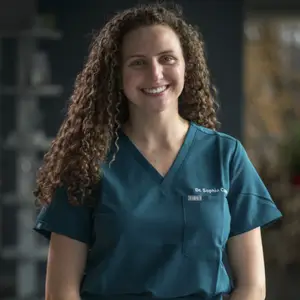 Dr. Sophia is smiling and looking forward wearing her green scrubs