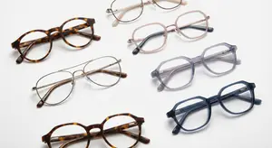 seven pairs of eyeglasses in different styles and colors displayed on a white background