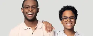 Portrait of a man and a woman with glasses smiling at the camera