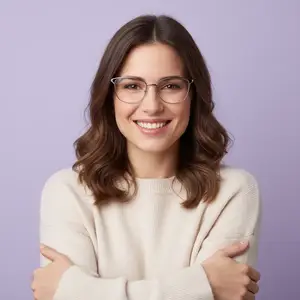 Woman wearing glasses and a white sweater smiling with arms crossed