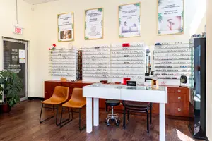 a room with a desk and chairs and a display case with glasses