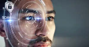 A man is staring at a scanning device with a light focused on his eye.